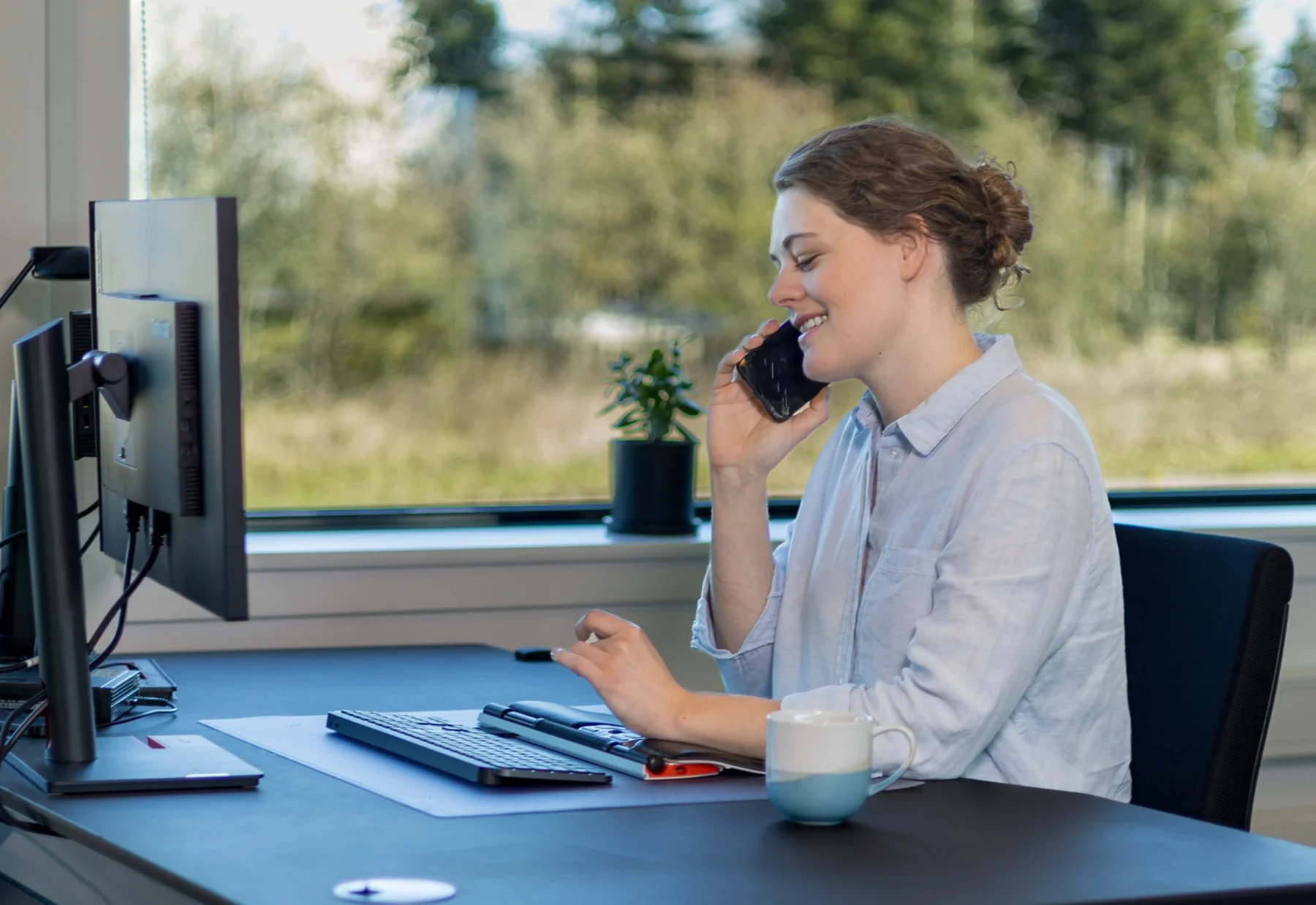 Rådgiver taler i telefon ved sin arbejdsplads