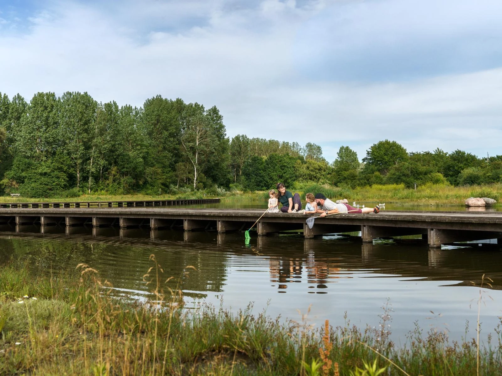 Familie fisker ved en sø