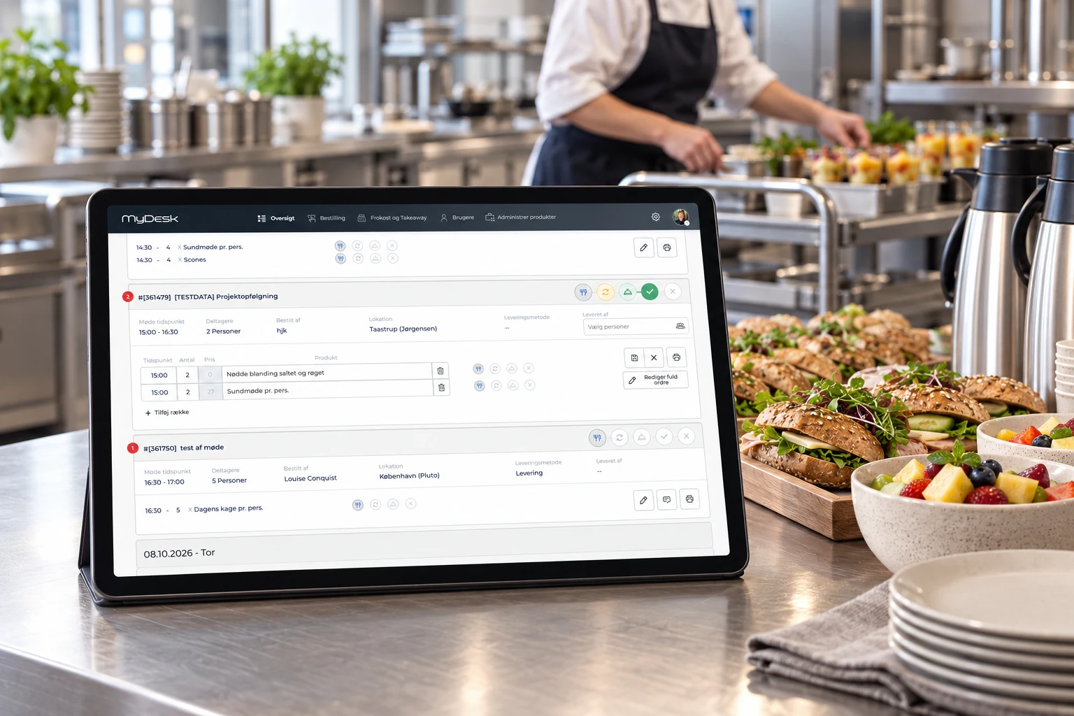 Illustratieve kantinekeuken met MyDesk-bestellingen op een tablet en een medewerker die de catering voor de dag klaarmaakt